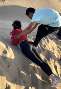 A Candid Teen Girl in Tights Lying on Her Tummy on the Sand-surfing Board