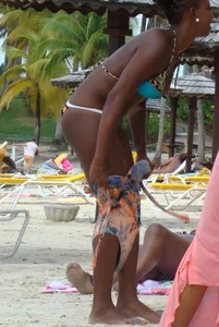 Sexy black babe in various bikinis on the beach while on vacation