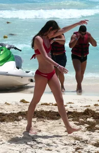Tall sexy skinny brunette on the beach in a red bikini