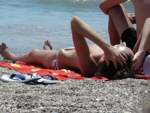 Sexy topless girl on the beach in a thong bikini
