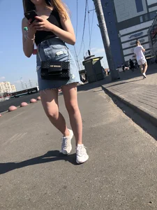A very cute street candid girl wearing a denim fringed skirt passing by, great legs