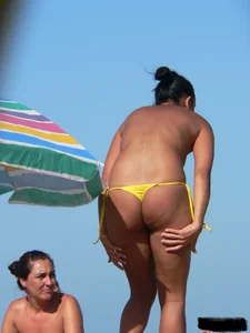Bunch of sexy babes on the beach topless and in thong bikinis