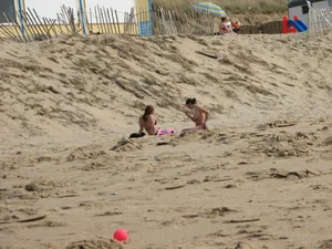 Topless beach girl with nice titties with her friend in a bikini