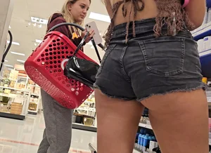 Booty peaking out of black denim shorts