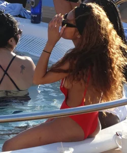 Sexy black girl in red swimsuit at the pool with side boob and a nice ass