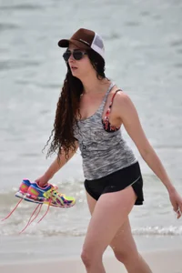 Brunette girl in black shorts and bikini top on the beach
