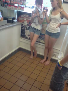 Two Barefoot Girls in Denim Shorts at the Supermarket Candid Photo