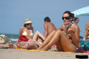 2 topless girls at the beach in thongs