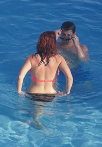 Sexy red haired girl in pink and black bikini at the pool