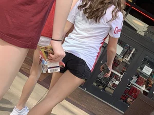 Bunch of girls in various outfits at a Cardinals baseball game