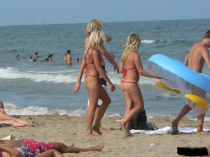 Sexy mom and daughter in red thongs at the beach