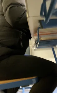 Female Student Sitting in Class Under Desk Creepshot