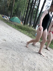 Cute Barefoot Girl in a Black Body Swimsuit Walking on a Road