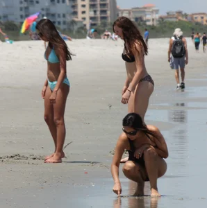 Brunette and redhead on the beach in bikinis looking sexy