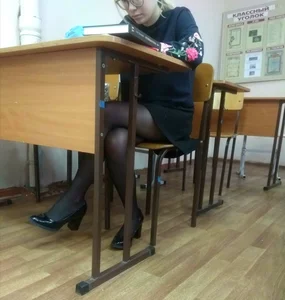 Cute College Bespectacled Teen in a Skirt And Black Pantyhose Sitting at Her Desk in a Classroom Creepshot