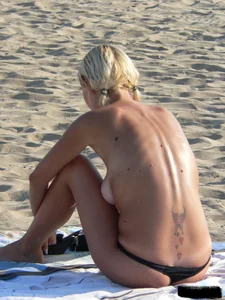 Blonde on the beach topless with big boobs and in a black thong