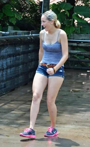 Cute blonde in denim shorts and a wet top