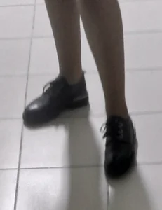 Slim Legs of a College Teen in a Skirt, Pantyhose And Shoes Standing in the Hallway Sneaky Photos