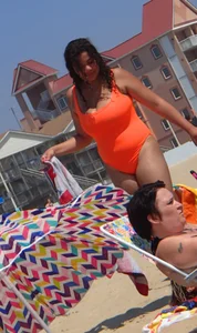 Beach girl with big boobs in an orange swimsuit