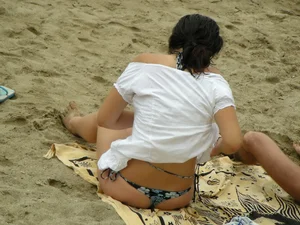 Sexy girl in a blue floral thong bikini at the beach