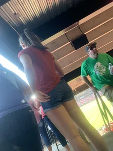 Bunch of girls in various outfits at a Cardinals baseball game
