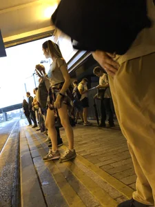 Cute Teen in Shorts on the Tram Stop