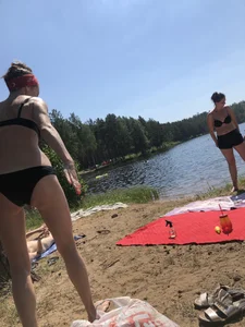 Skinny Girl in Swimsuit Lying on the Lake Beacg Topless and Bending Over