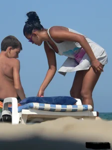 Hot ass topless beach girl with great tits lets her little brother oil up her ass in thong bikini