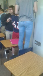 Skinny Girl in Tight Jeans Standing on a Chair in Classroom Photo