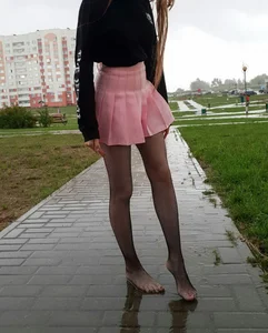 Girl in Short Pink Skirt and Pantyhose Shoeless on Wet Pavement