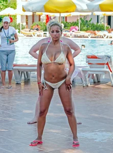Big boobed blonde milf dancing by the pool in a bikini