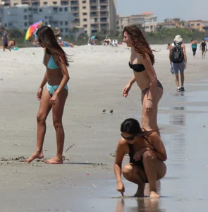 Brunette and redhead on the beach in bikinis looking sexy