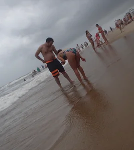 Cute lady at the beach with a nice body in a floral swimsuit