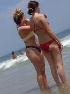 Thick girl and her skinny friend in bikinis at the beach