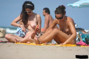 2 topless girls at the beach in thongs