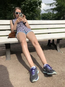Candid girl sitting on a park bench, nice long legs