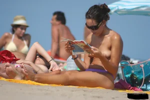 2 topless girls at the beach in thongs