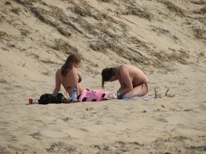 Topless beach girl with nice titties with her friend in a bikini
