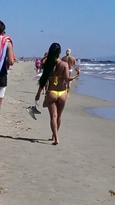 Beach babe with a nice ass and big tits in yellow thong bikini