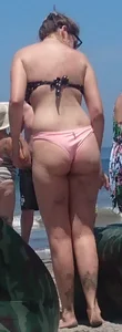 Chunky beach blonde babe in a pink thong bikini