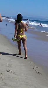 Beach babe with a nice ass and big tits in yellow thong bikini