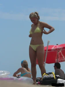 Sexy blonde on the beach in a yellow thong bikini