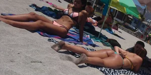2 beach friends in bikinis,one thick and in a thong