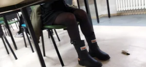 Legs of a College Girl in Black Pantyhose Under the Desk in a Classroom Photo