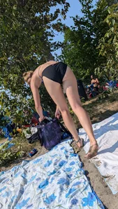 A pretty brown haired woman bending over with her nice ass in a black bikini on the beach. oc