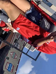 Bunch of girls in various outfits at a Cardinals baseball game