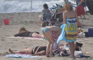 Bikini girls setting up for a day on the beach in their bikinis