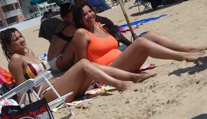Beach girl with big boobs in an orange swimsuit