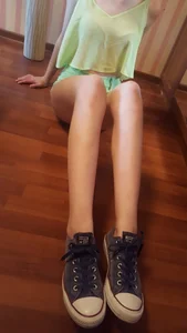 Skinny Girl in Mini Shorts and a Blouse Sitting on the Floor Selfie