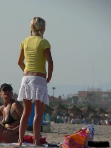 Blonde on the beach topless with big boobs and in a black thong